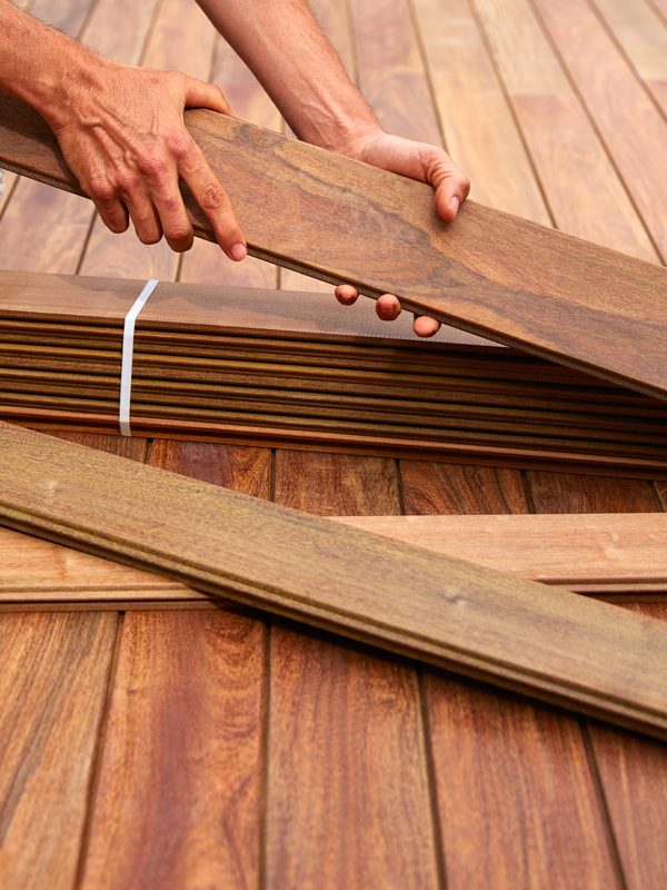 Ipe decking installation with carpenter hands holding tropical wood slats